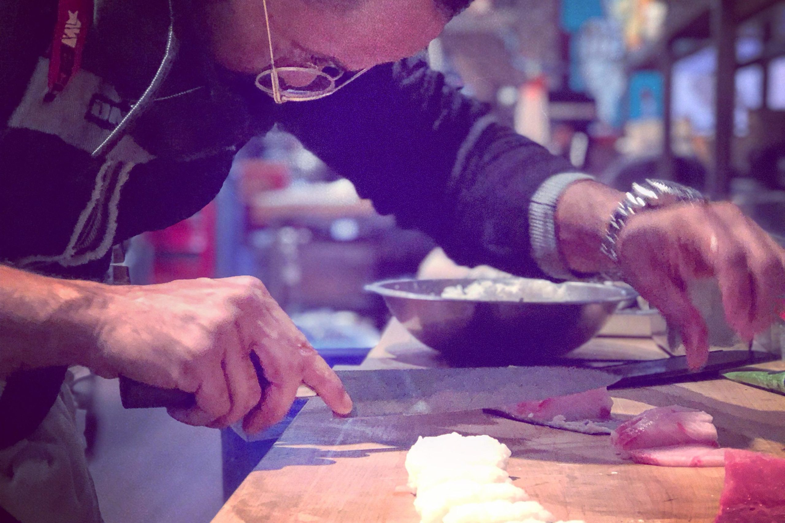 Tony shaping nigiri rice on a wooden board, Hamachi Hunters