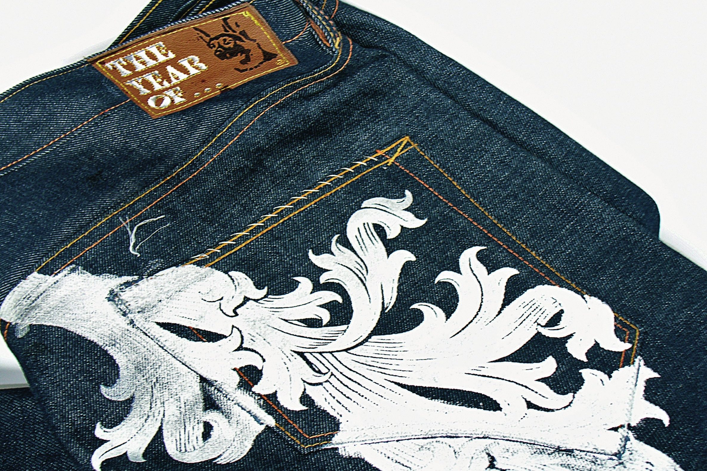 White foliate embroidery across the back pocket of The Year of… jeans