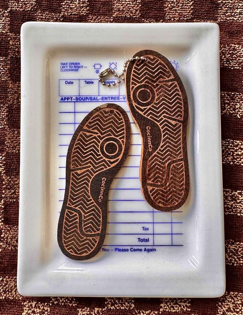 Sole-shaped cocinnco cinnamon insoles, wood-burned with tread and the cocinnco mark